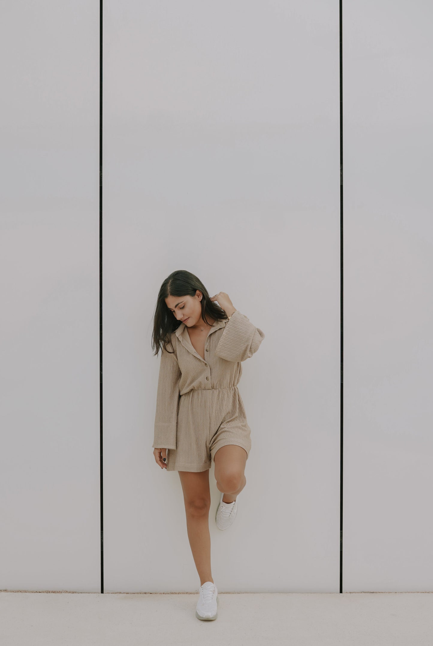 A girl with a soft beige classic and comfortable ladies romper made with flared sleeves and thick cuffs