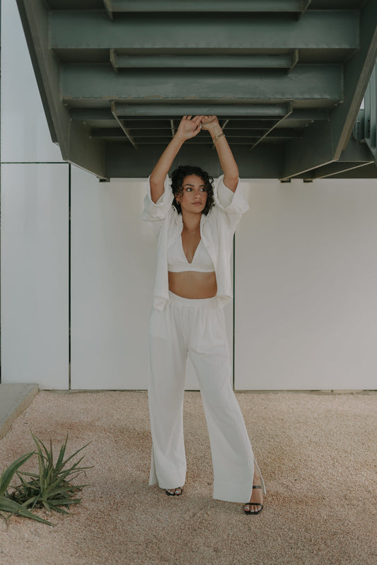 Girl posing in white loungecset for Women comprising of oversized shirt loose pant and a bralette