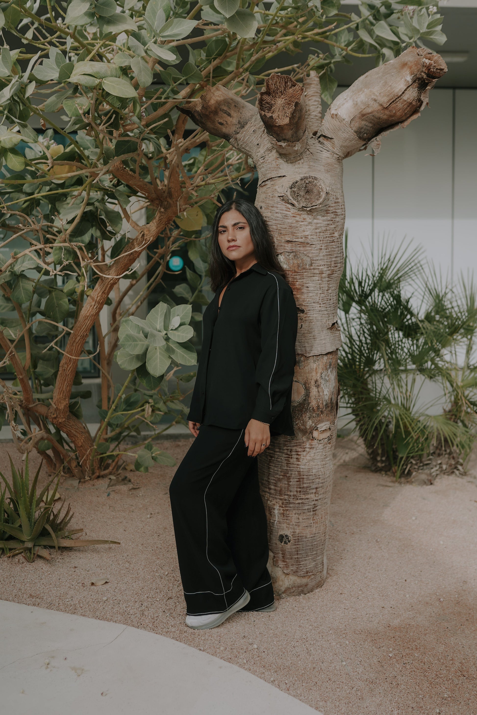 Girl posing in a black loungewear with a tree in background