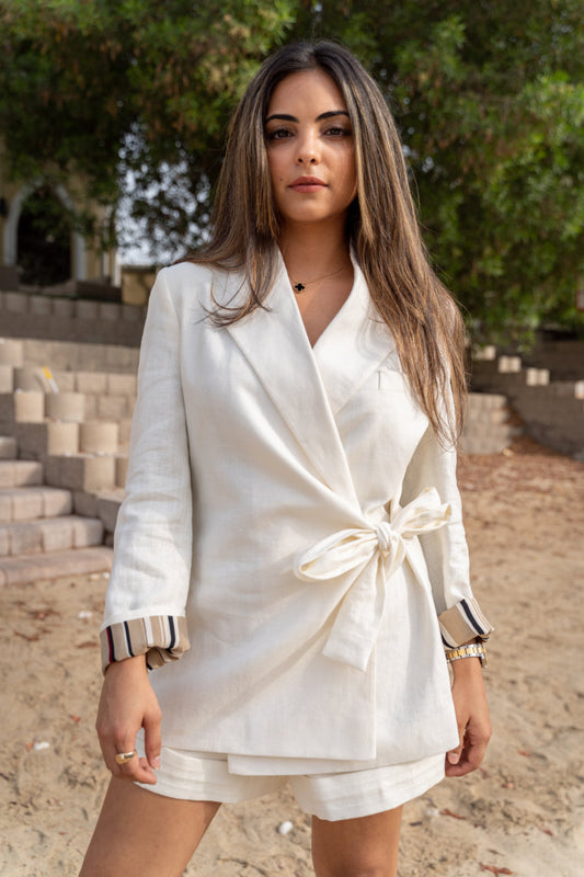 A white side knot ladies blazer made with a striped printed lining and paired with classic front zip shorts