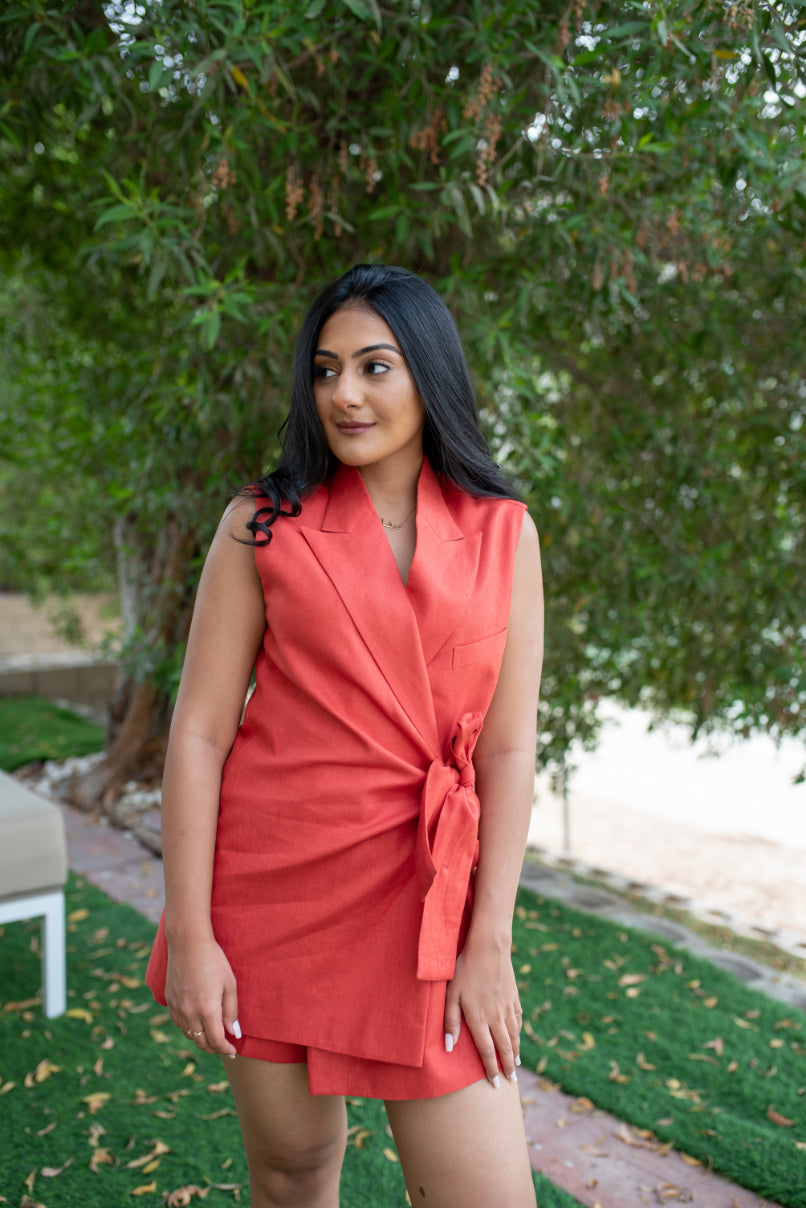 Red sleeveless side knot ladies blazer, paired with coordinated front zip shorts under.